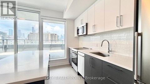 A modern kitchen with a view of the cityscape outside the window.