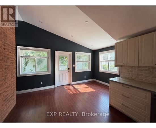 A room with a brick wall and wooden floors.