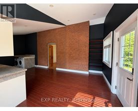 A room with a wooden floor and a brick wall.
