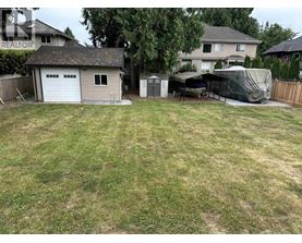 A backyard with a shed and a covered patio.