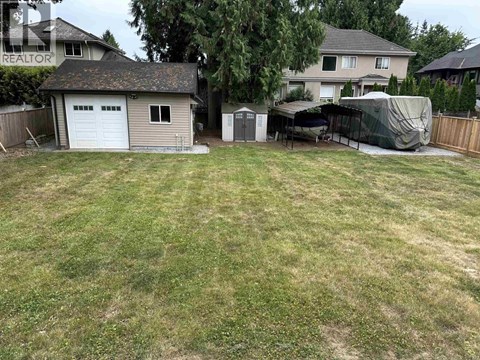 A backyard with a shed and a covered patio.