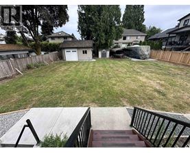 A backyard with a deck and a fence.