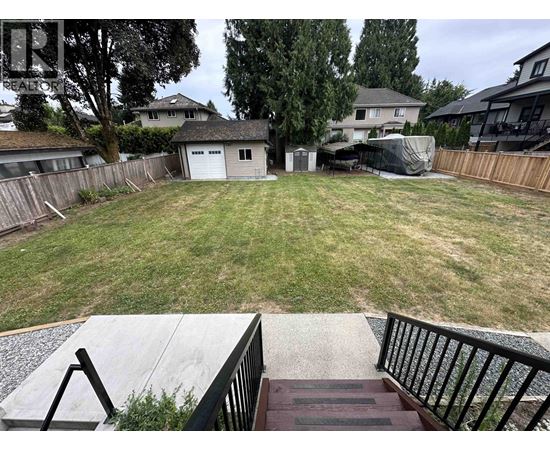 A backyard with a deck and a fence.