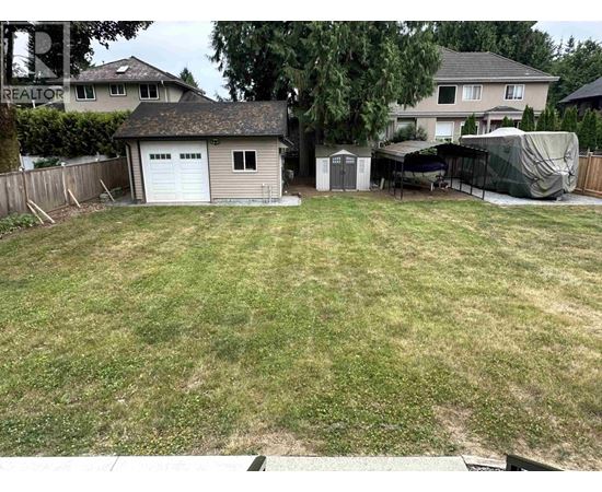 A backyard with a shed and a covered patio area.