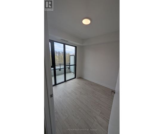 A room with a wooden floor and a sliding glass door.