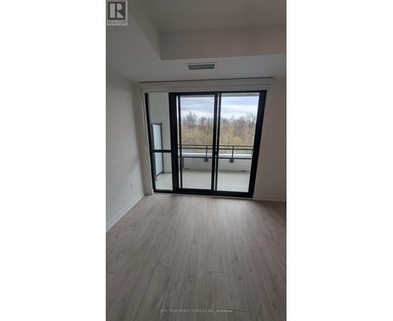 A room with a sliding glass door leading to a balcony.