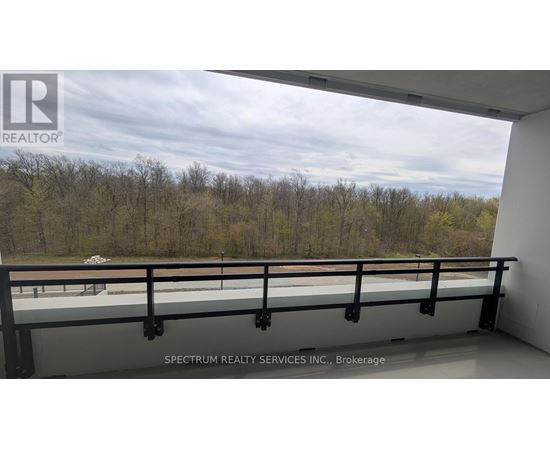 A balcony with a railing and a view of trees and a cloudy sky.