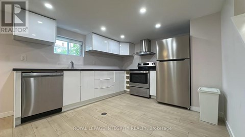A modern kitchen with stainless steel appliances and white cabinets.