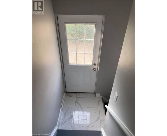 A hallway with a door leading to a backyard.