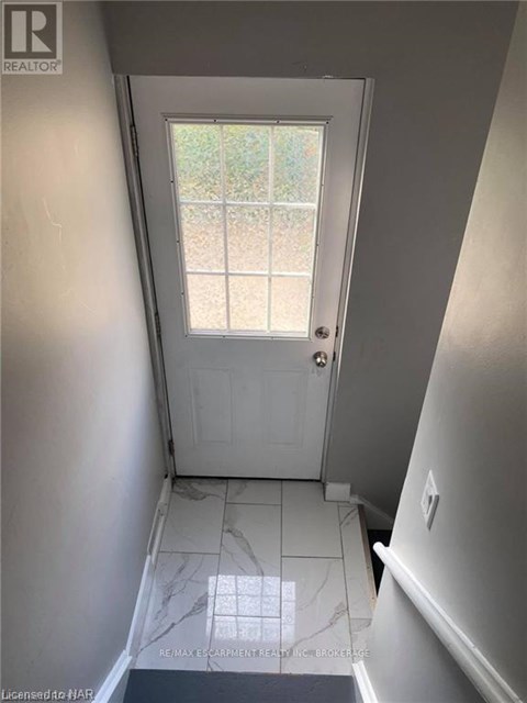 A hallway with a door leading to a backyard.