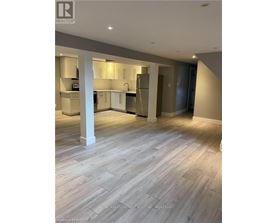 A spacious kitchen and living room with wooden flooring and modern appliances.