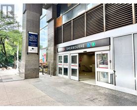 The entrance to Sherbourne subway station with a blue sign on the pillar.