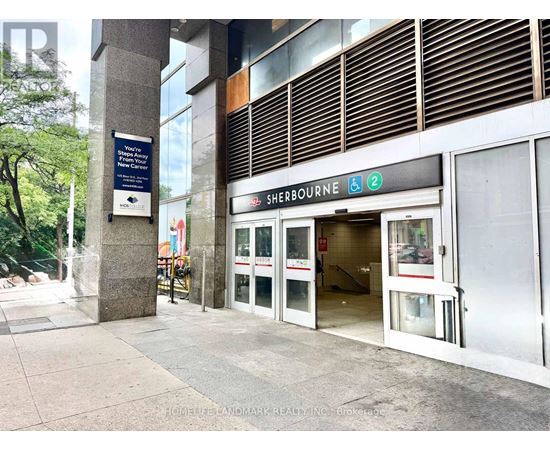 The entrance to Sherbourne subway station with a blue sign on the pillar.