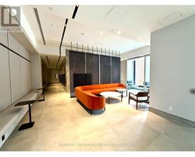 A modern living room with a black and orange sofa.