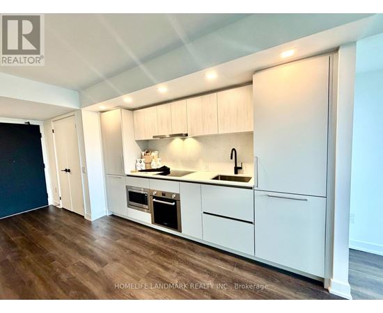 A kitchen with white cabinets and a wooden floor.