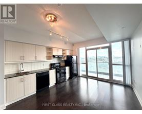 A kitchen with white cabinets and black appliances.