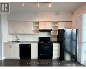 A kitchen with black appliances and white cabinets.