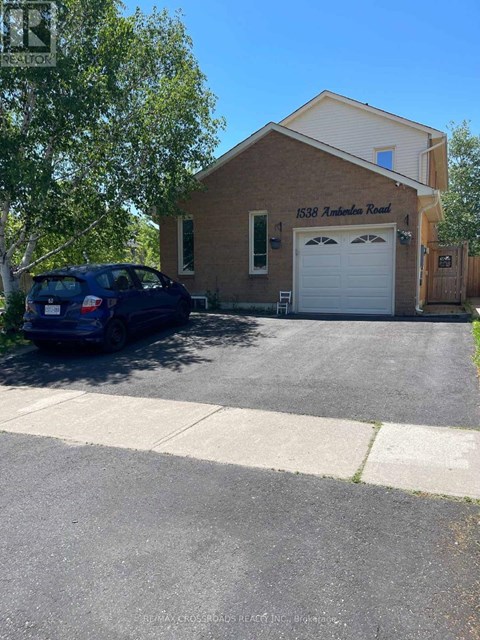 A blue car is parked in front of a garage on Andover Road.