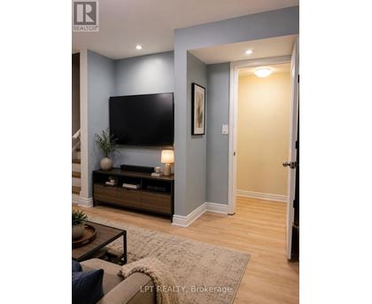 A living room with a flat screen TV and a wooden cabinet.