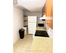 A kitchen with a white fridge, microwave, and oven.