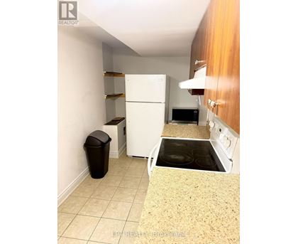 A kitchen with a white fridge, microwave, and oven.