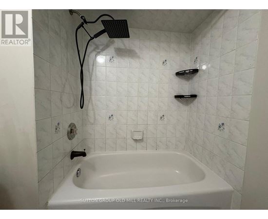 A white bathtub in a bathroom with a shower head above it.
