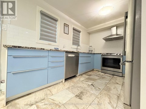 A kitchen with blue cabinets and a tiled floor.