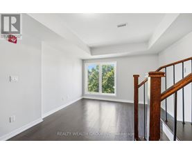 A spacious room with a staircase leading to the second floor.