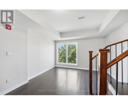 A spacious room with a staircase leading to the second floor.