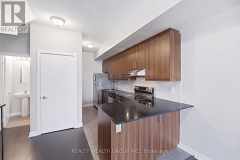 A modern kitchen with wooden cabinets and a black countertop.