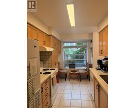 A kitchen with wooden cabinets and a window seat.