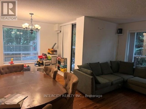 A living room with a brown table and grey couches.
