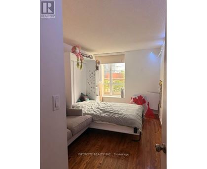 A bedroom with a bed, a couch, and a window.