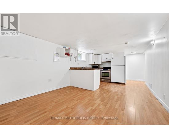 A spacious kitchen with white cabinets and a wooden floor.