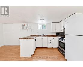 A kitchen with white cabinets and a brown countertop.