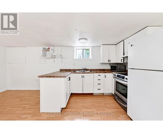 A kitchen with white cabinets and a brown countertop.