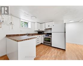 A kitchen with white cabinets and a brown granite countertop.