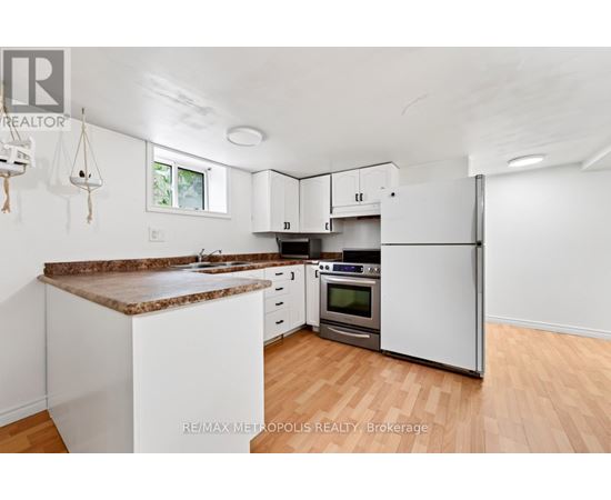 A kitchen with white cabinets and a brown granite countertop.