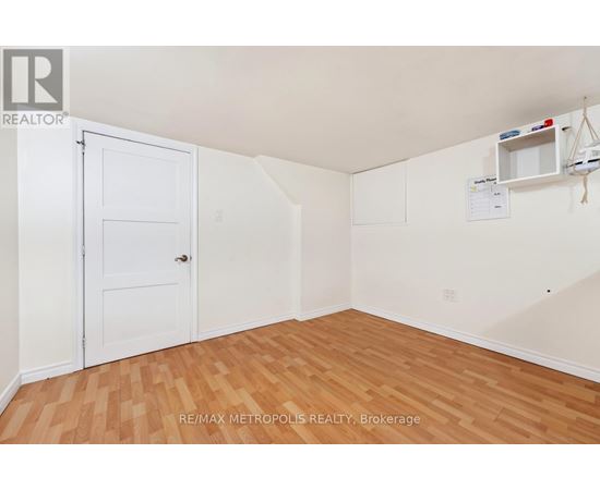 A room with a white door and wooden flooring.