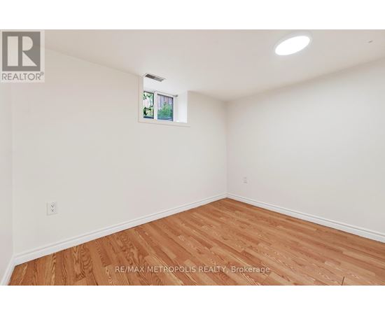 A room with wooden flooring and white walls.