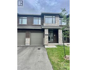 A modern house with a grey garage door is for sale.