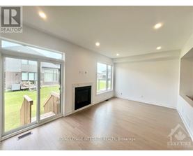 A spacious living room with a fireplace and sliding glass doors leading to a backyard.