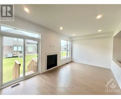 A spacious living room with a fireplace and sliding glass doors leading to a backyard.