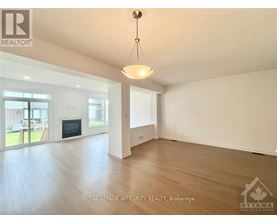 A spacious room with a fireplace and sliding glass doors leading to a patio.