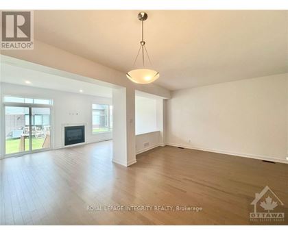 A spacious room with a fireplace and sliding glass doors leading to a patio.