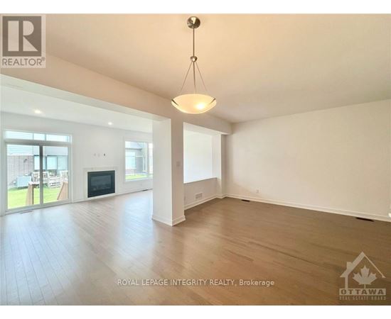A spacious room with a fireplace and sliding glass doors leading to a patio.