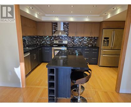A kitchen with a black counter top and wooden cabinets.