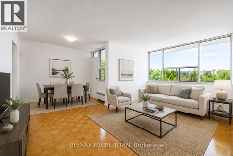 A well-lit living room with a dining table and chairs.