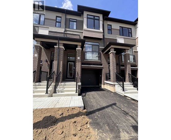 A modern two-story residential building with a black front door and a small front yard.