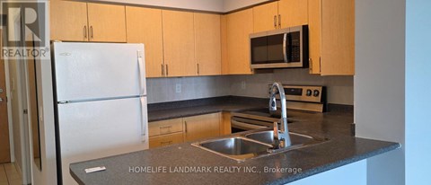 A kitchen with a white fridge and a black counter top.